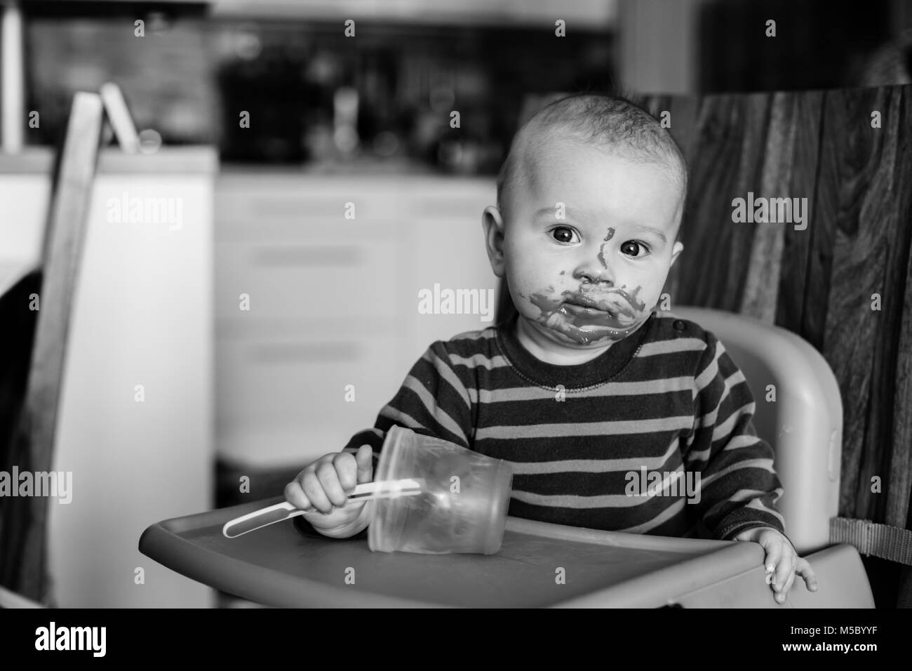Little baby boy, eating mashed food for the first time in his life Stock Photo