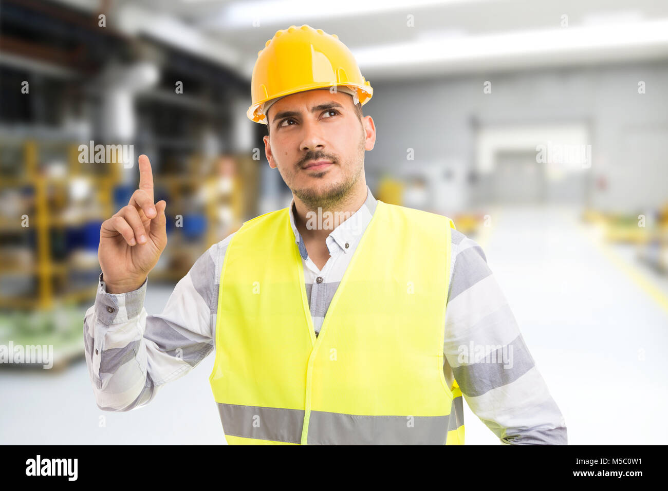 Smart engineer raising finger as having an idea concept inside factory ...