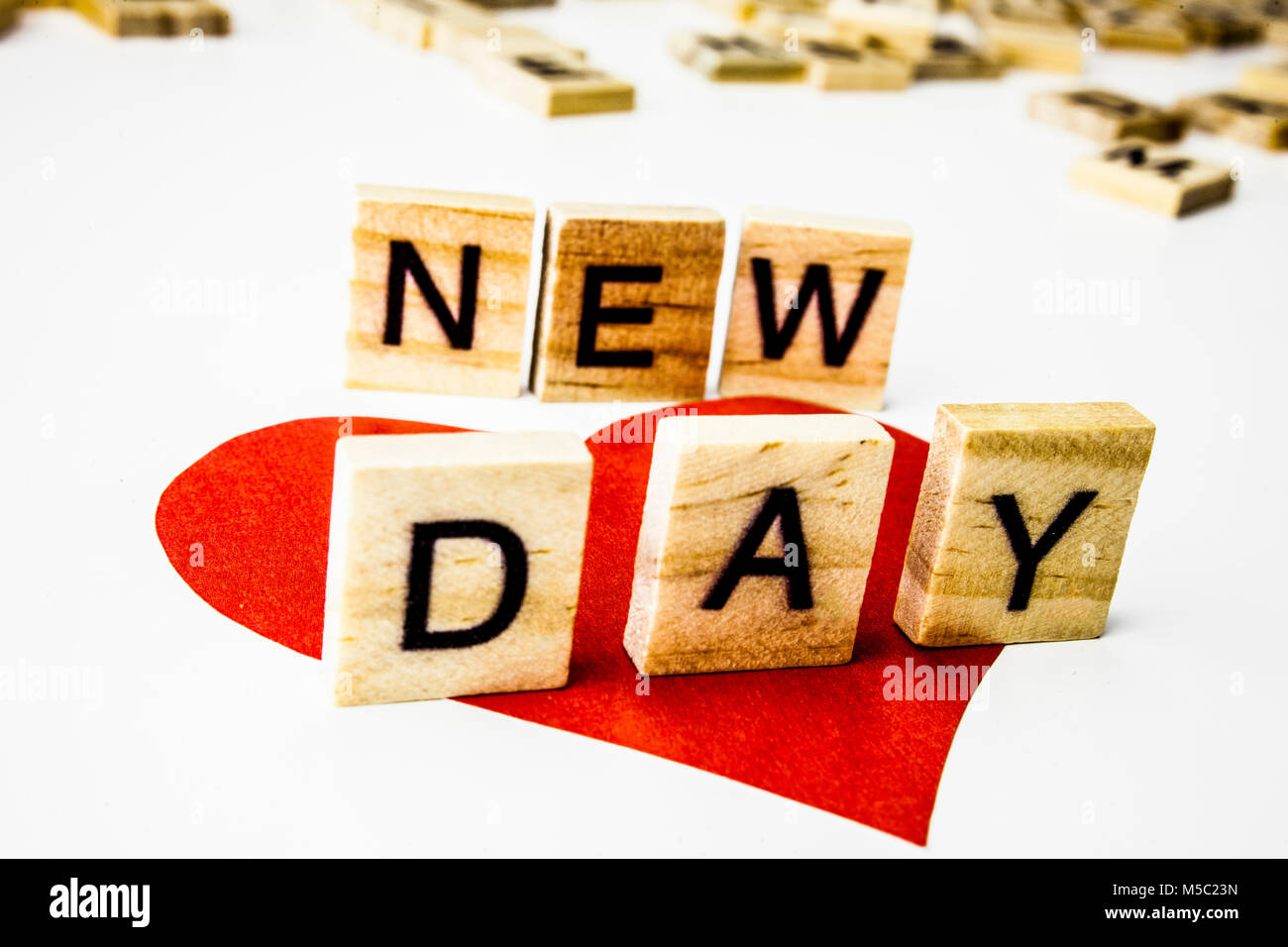 Wooden letters spelling the phrase NEW DAY on white background. Stock Photo