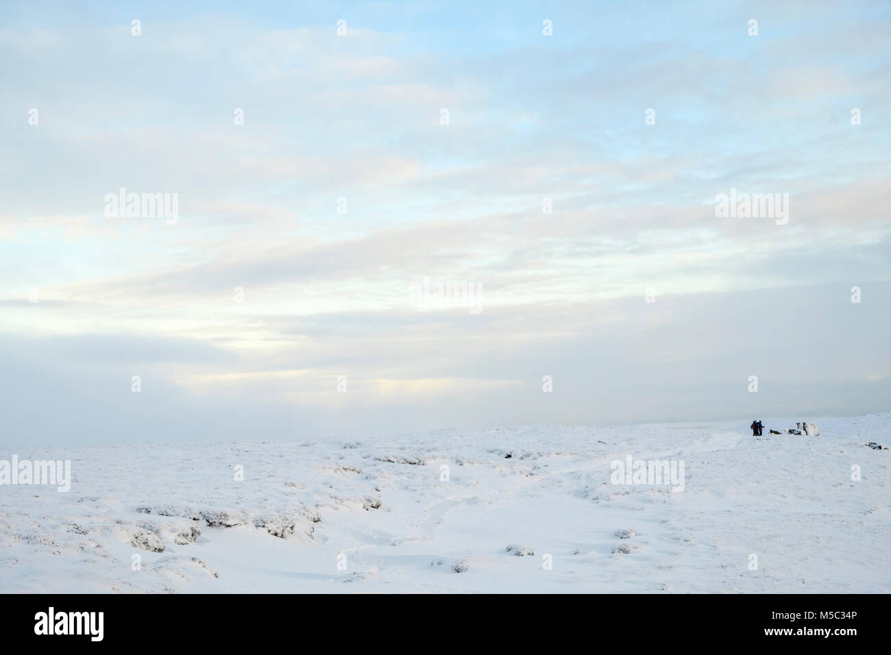 Winter landscape. Snow covered moorland with walkers in the distance, Edale Moor, Kinder Scout, Derbyshire, Peak District National Park, England, UK Stock Photo