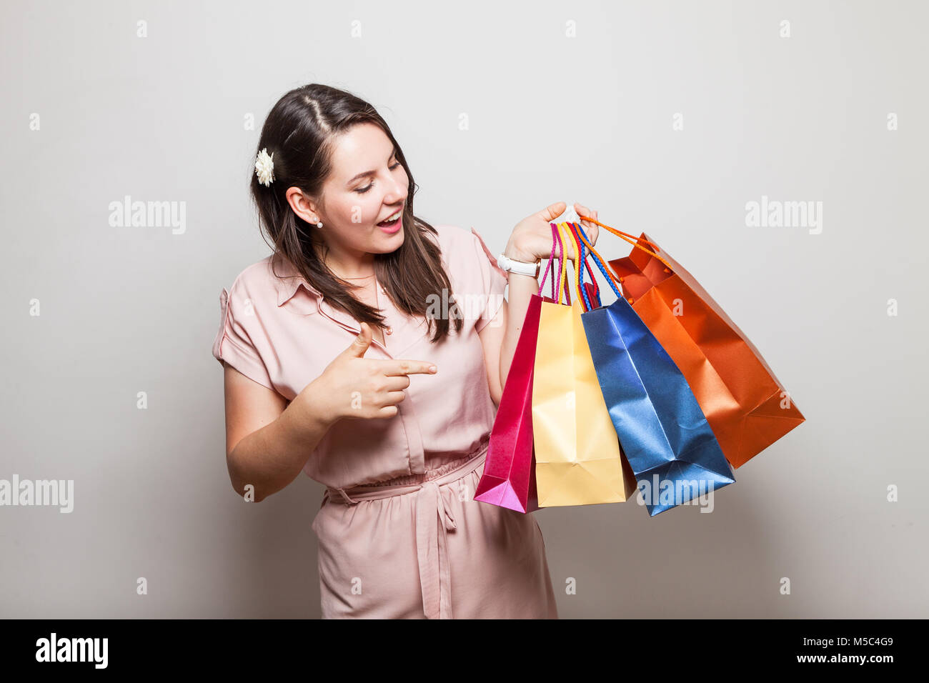 Modern teenager in a dress holds gift bags from her birthday party Stock Photo