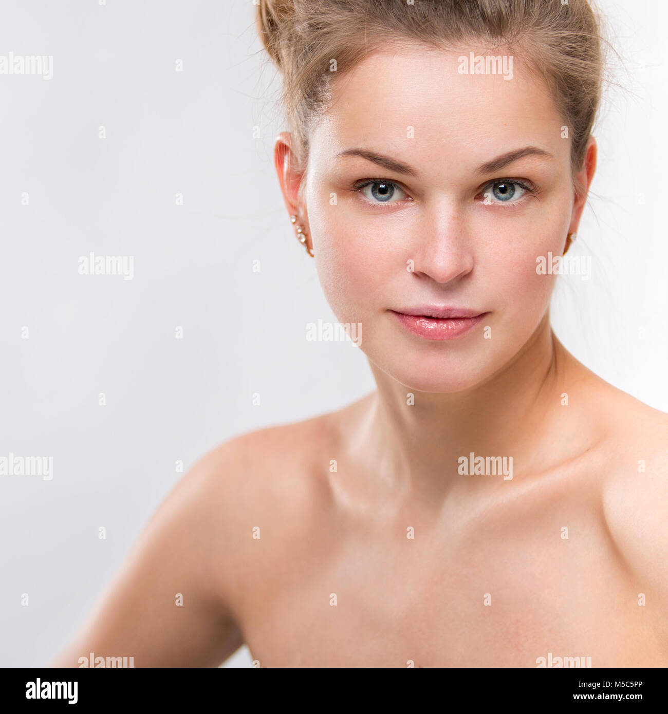 Portrait of a beautiful young smiling woman on a gray background Stock Photo