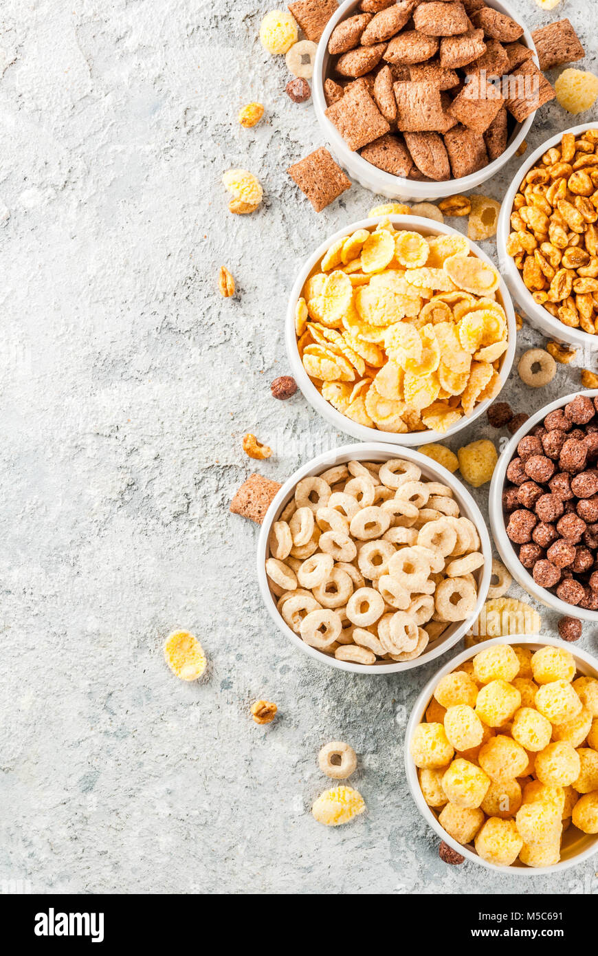 Set of various breakfast cereal corn flakes, puffs, pops, grey stone table  copy space top view Stock Photo - Alamy
