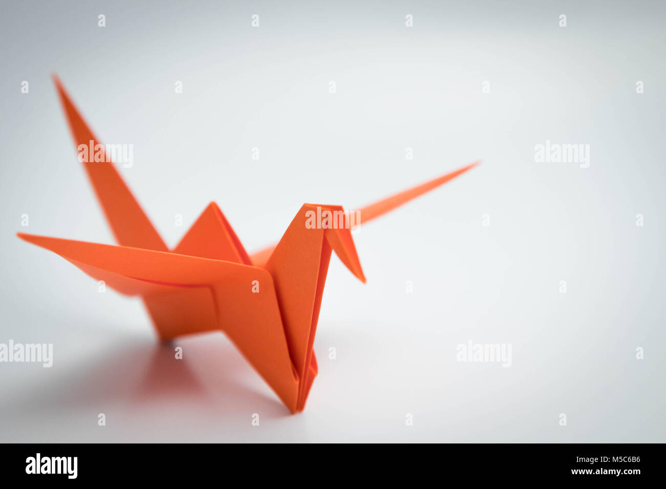 single orange bird origami isolated Stock Photo