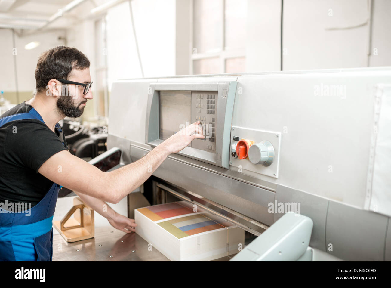 Man working with cutting machine at the printing plant Stock Photo