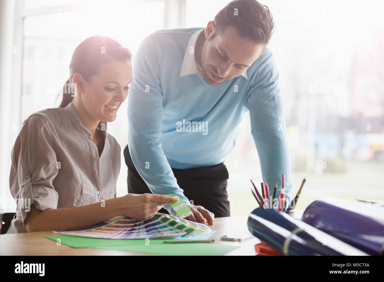 Young business people discussing over color swatches at office desk Stock Photo