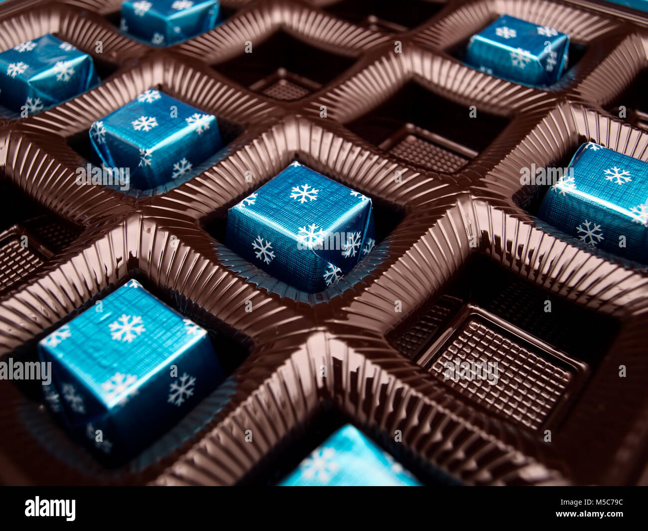 Box with chocolate candies in a blue wrap. Stock Photo