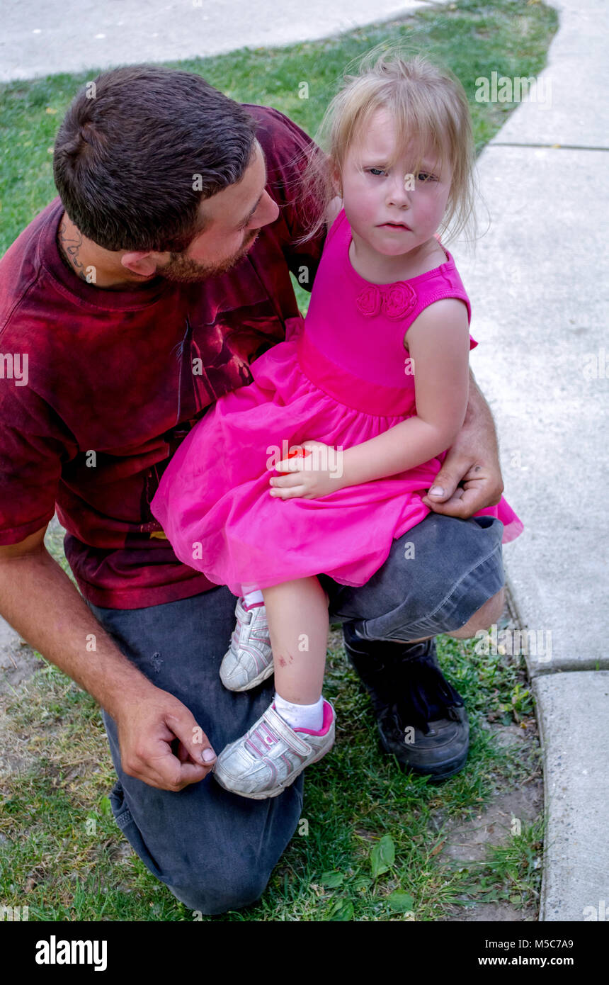 hurt little girl being comforted  by dad Stock Photo