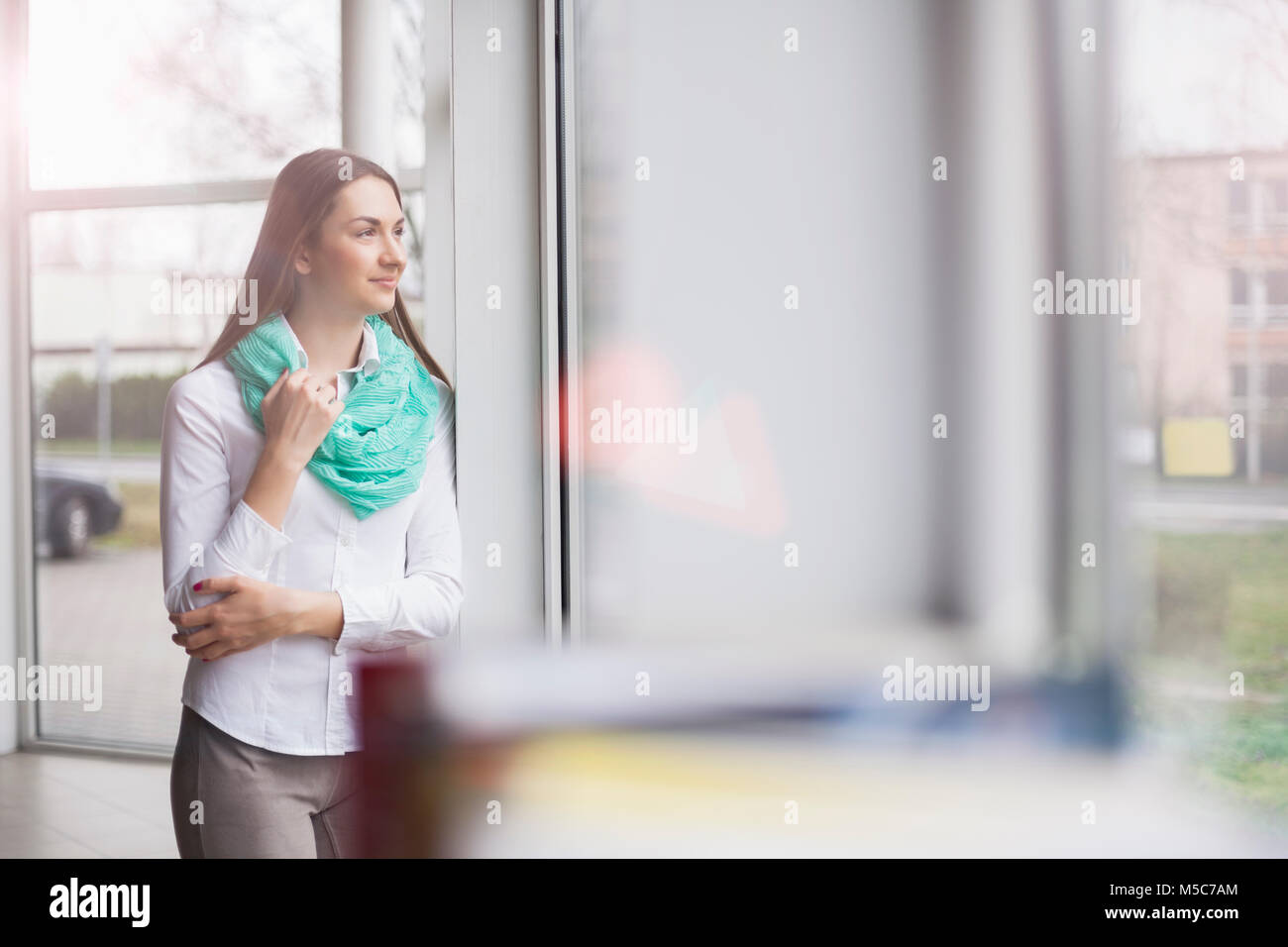 Beautiful young businesswoman looking away in office Stock Photo - Alamy