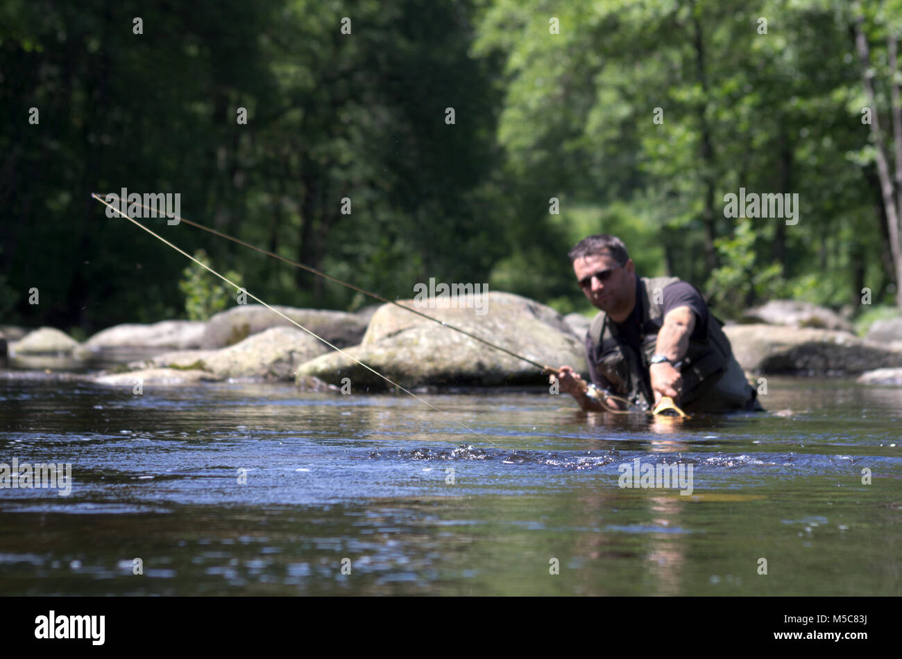 Fly fishermen in a trout river. Fly fishing scene Stock Photo