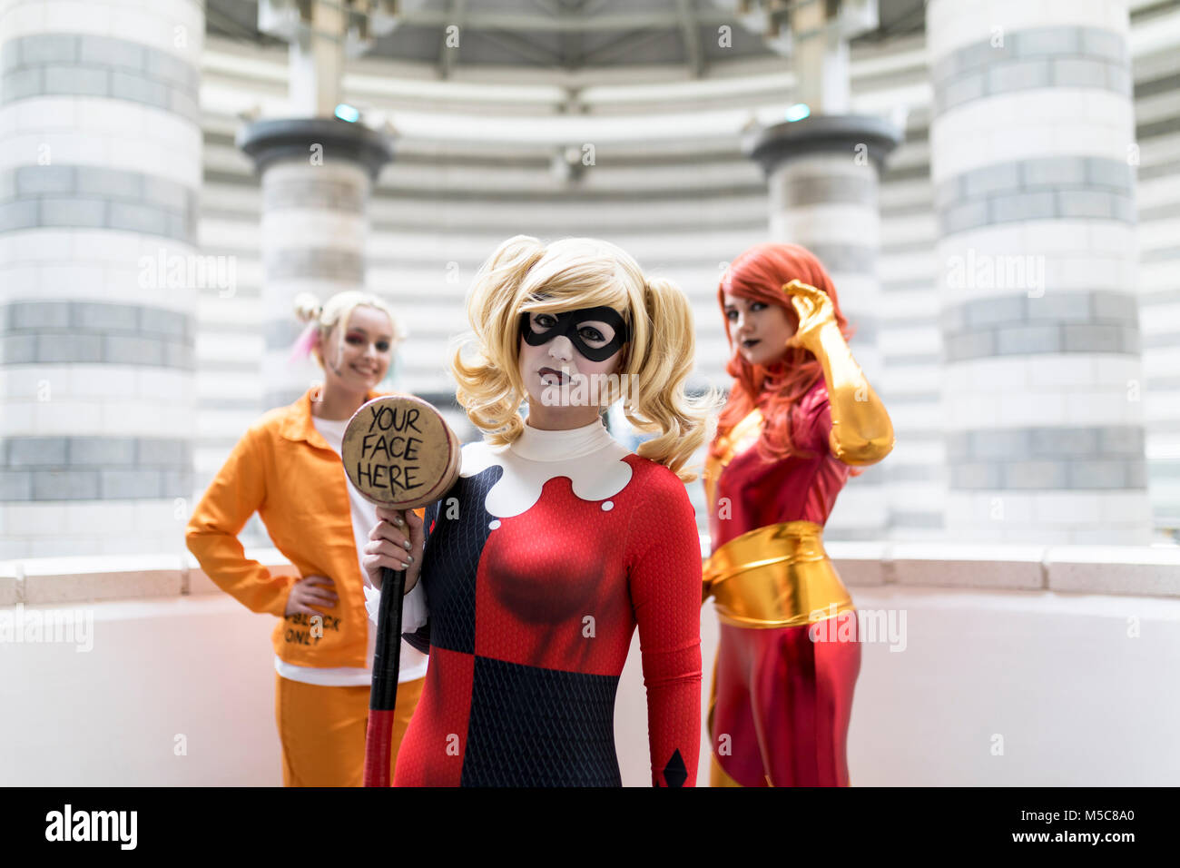 Doncaster Comic Con 11th Feruary 2018 at The Doncaster Dome UK. Three young women cosplay as Harley Quinn Suicidé Squad and Marvel’s Jean Grey Phoenix Stock Photo