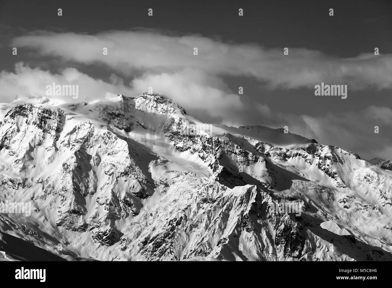 Black and white winter snowy mountains at nice sunny evening. Caucasus Mountains. Georgia, region Svaneti. Stock Photo