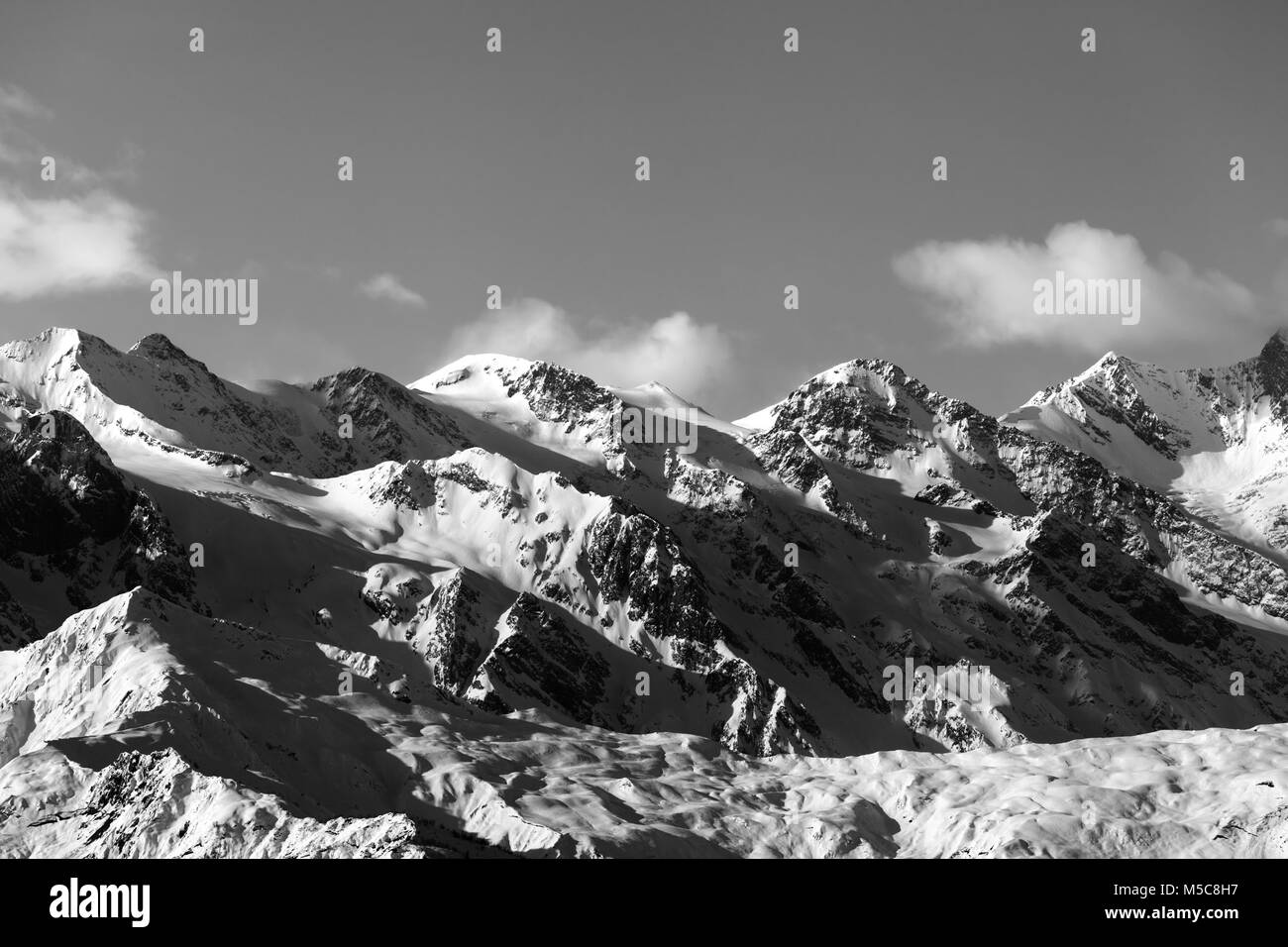 Black and white snowy winter mountains at sunny evening. Caucasus Mountains. Georgia, region Svaneti. Stock Photo