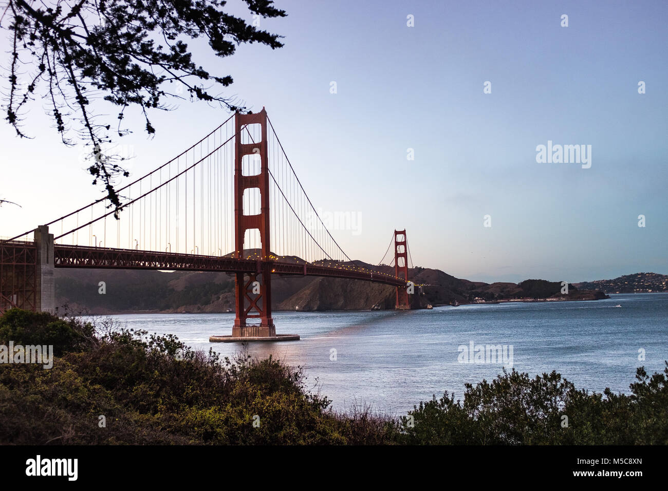 Golden Gate bridge at dawn with pink sky and calm water , San Francisco