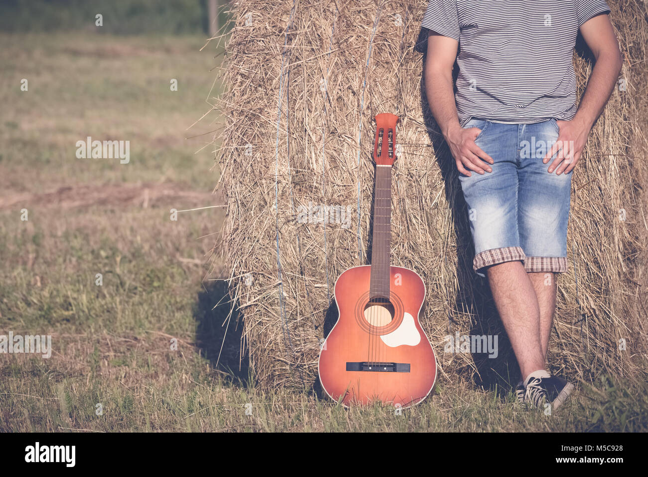 Close up of modern guy with acoustic guitar outdoors Stock Photo