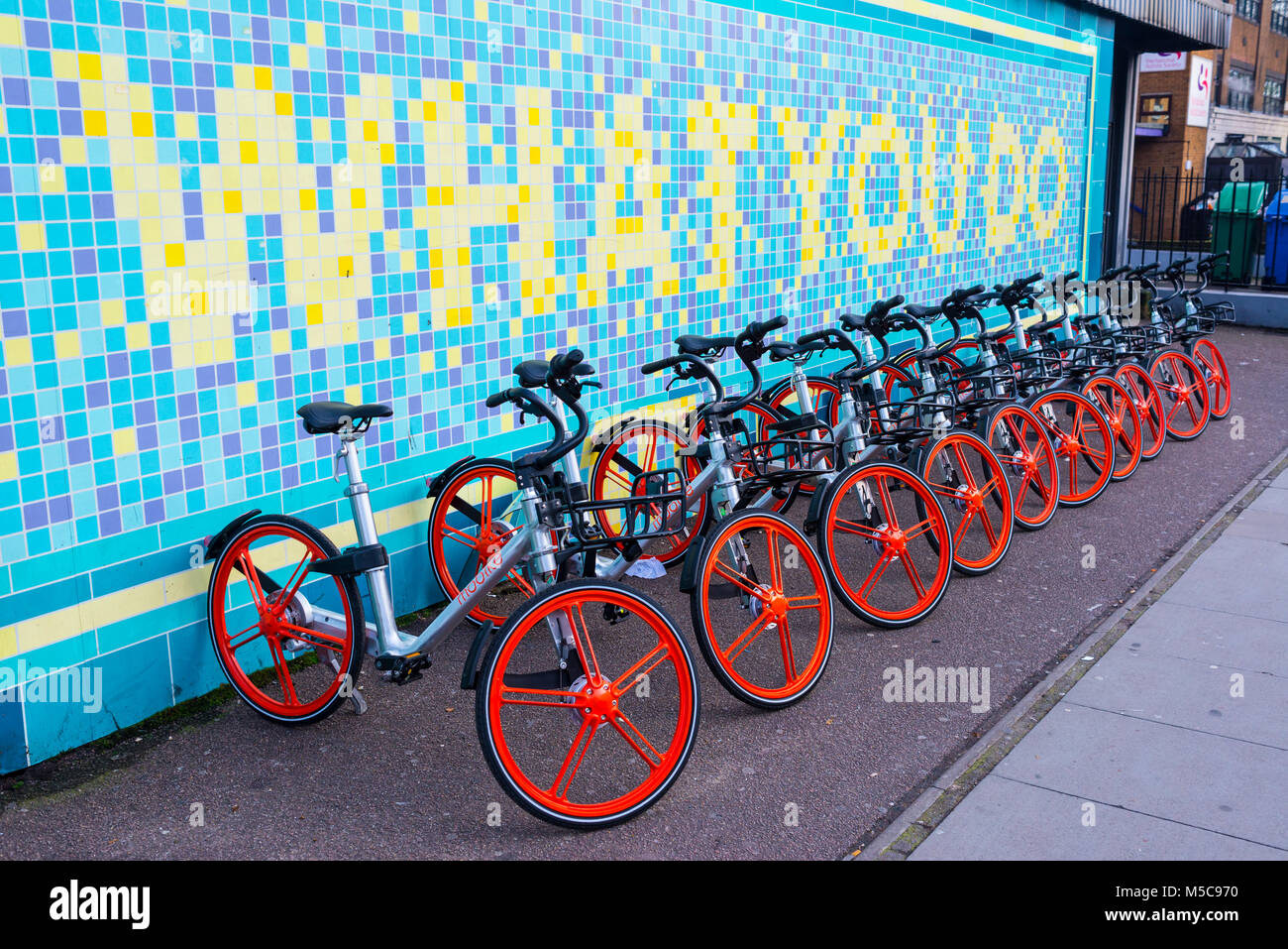 Mobike bicycles parked at a docking station in Torrens street, Angel, London. Mobike is a low cost bike-sharing scheme hugely popular in China. Stock Photo