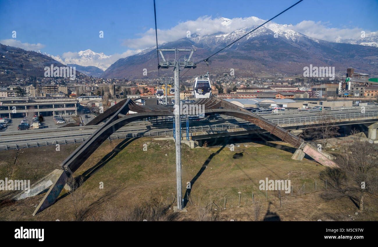 Aosta, Italy - Feb 19, 2018: Gondola cable car to ski resort of Pila.  Looking towards valley at town of Aosta before crossing a major highway  Stock Photo - Alamy
