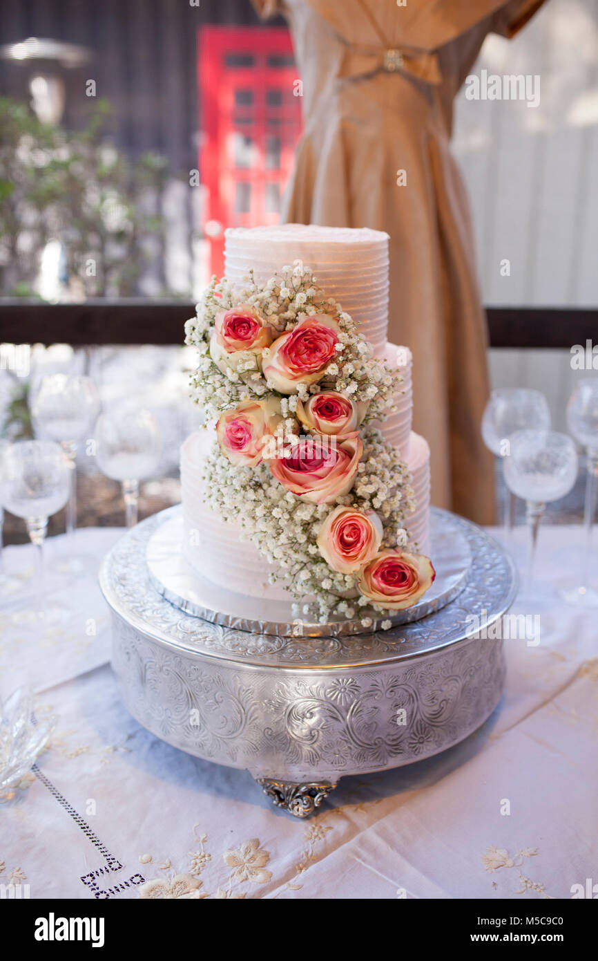 Beautiful three tiered wedding cake with roses, shallow focus on roses Stock Photo