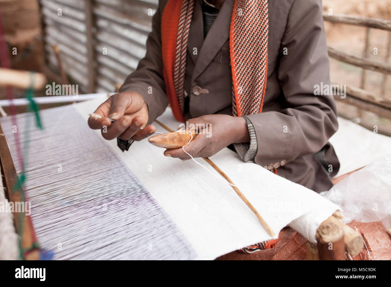 Hands of a man making cloth on a traditional loom in Africa Stock Photo