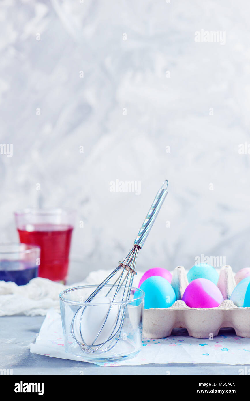 Painting Easter eggs with a whisk. Minimalist holiday decorating. Easy Easter lifehack with copy space. Stock Photo