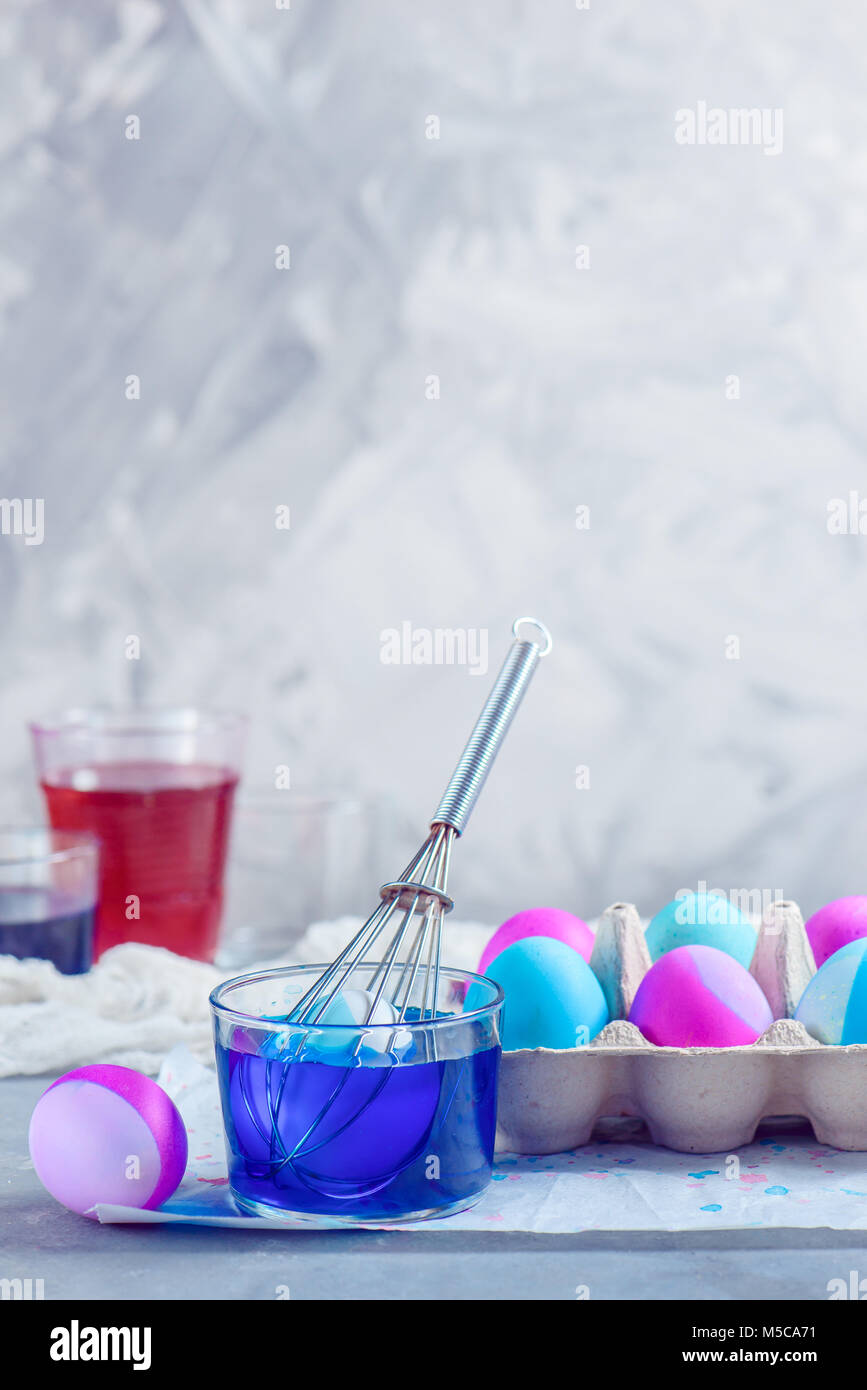 Fresh Easter eggs painted in shades of pink and blue. Holiday preparations in progress. Whisk lifehack. Stock Photo