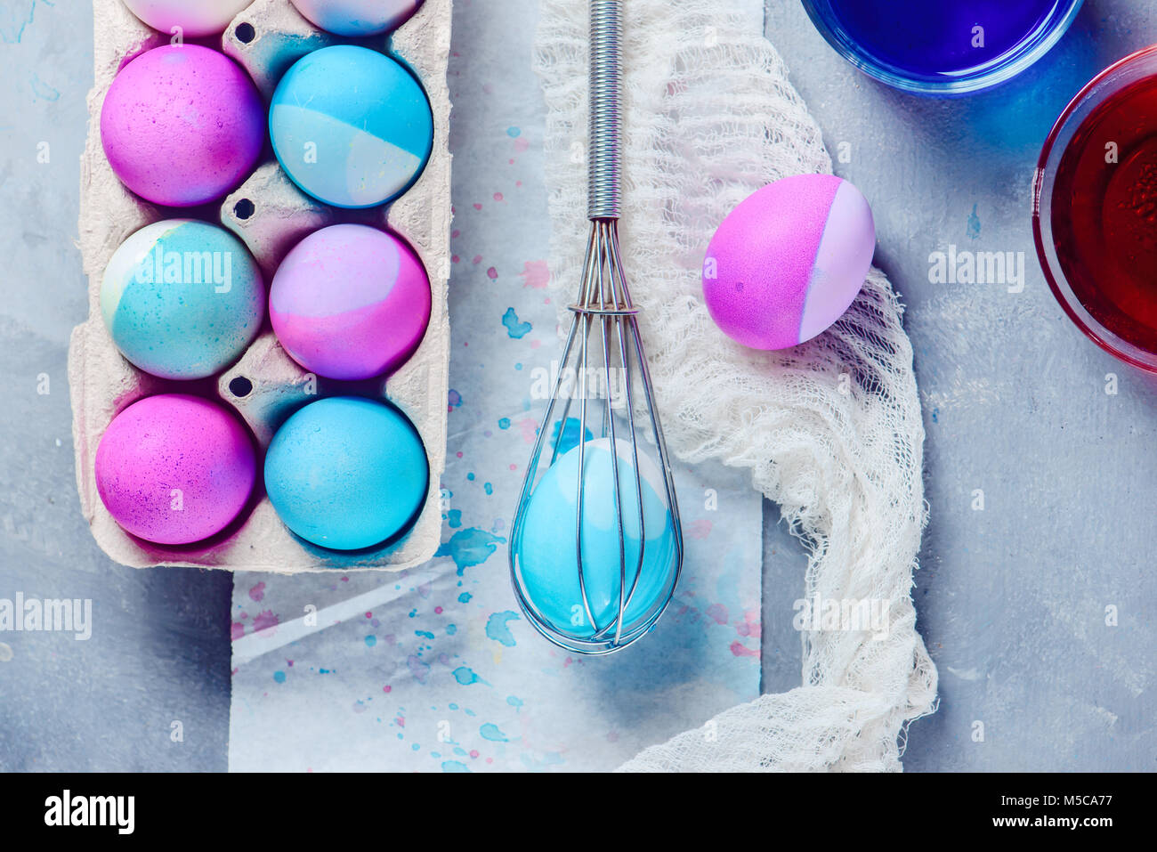 Header with painting Easter eggs with a whisk. Minimalist holiday decorating. View from above with copy space. Stock Photo