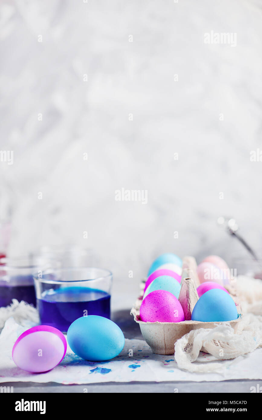Easter eggs in a paper carton. Modern high key holiday scene with shades of blue and purple. Happy Easter background with copy space. Stock Photo