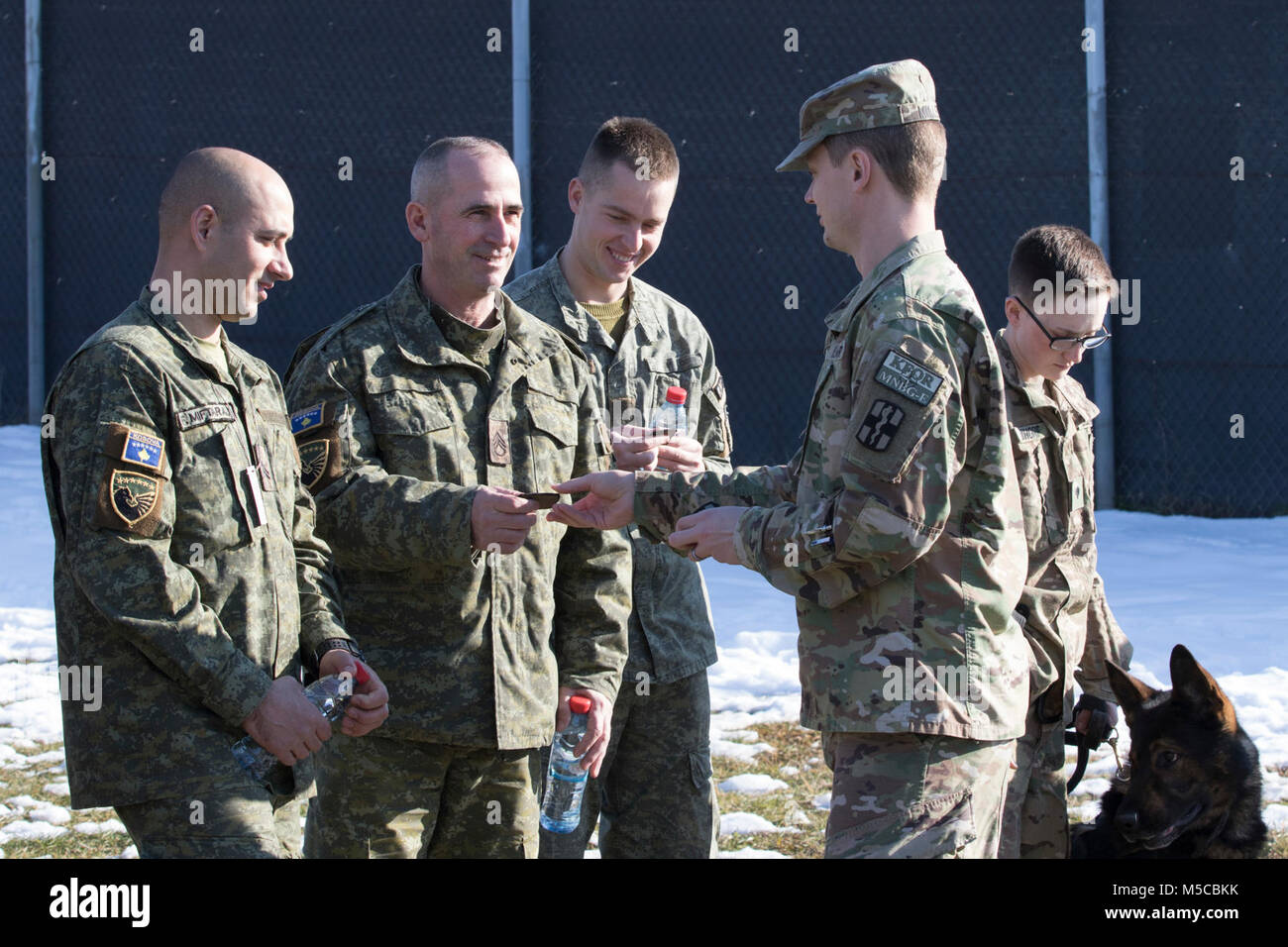 Capt. Jarrod Miller a field service veterinarian for KFOR Multinational Battle Group-East, Task Force Medical, exchanges unit patches with Kosovo Security Force, Search and Rescue soldiers after a Military Working Dog demonstration, Jan. 31, 2018 on Camp Bondsteel, Kosovo. (U.S. Army Stock Photo