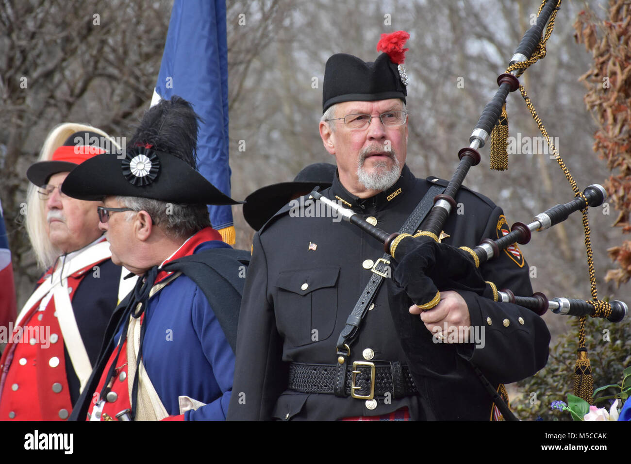 A bagpipe player prepares to play a ceremony honoring the 245th