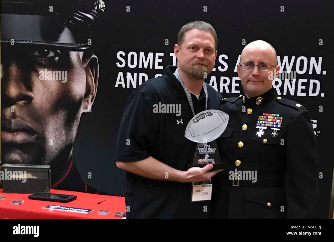 U.S. Marine Corps Maj. Peter E. Ankney, commanding officer of Marine Corps Recruiting Station Salt Lake City, poses with Jared Lish, Bear River High School Football Coach, during the Las Vegas Glazier Clinic Feb. 9, 2018. Ankney presented Lish the Semper Fidelis Coach Award for his embodiment of the Marine Corps motto: Semper Fidelis. Lish not only focused on winning on the field but developing young men and women who can win in life. (U.S. Marine Corps Stock Photo