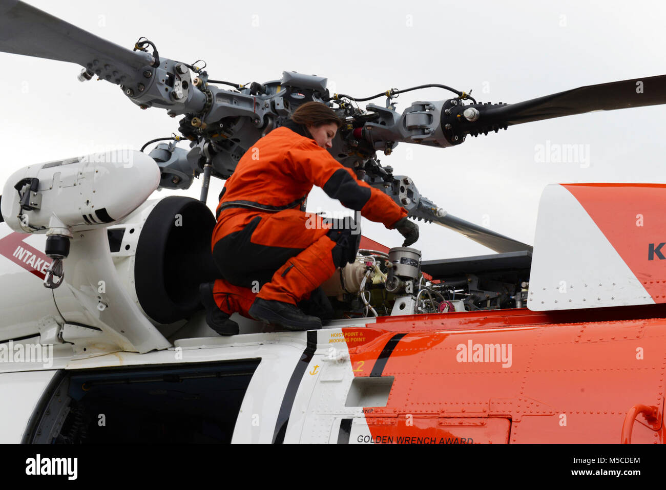 Petty Officer 2nd Class Eileen Best, an aviation maintenance technician, performs post-flight checks on an MH-60 Jayhawk helicopter at Coast Guard Air Station Kodiak, Alaska, Feb. 13, 2018. Post-flight checks are conducted to evaluate the condition of the aircraft after every flight. U.S. Coast Guard Stock Photo