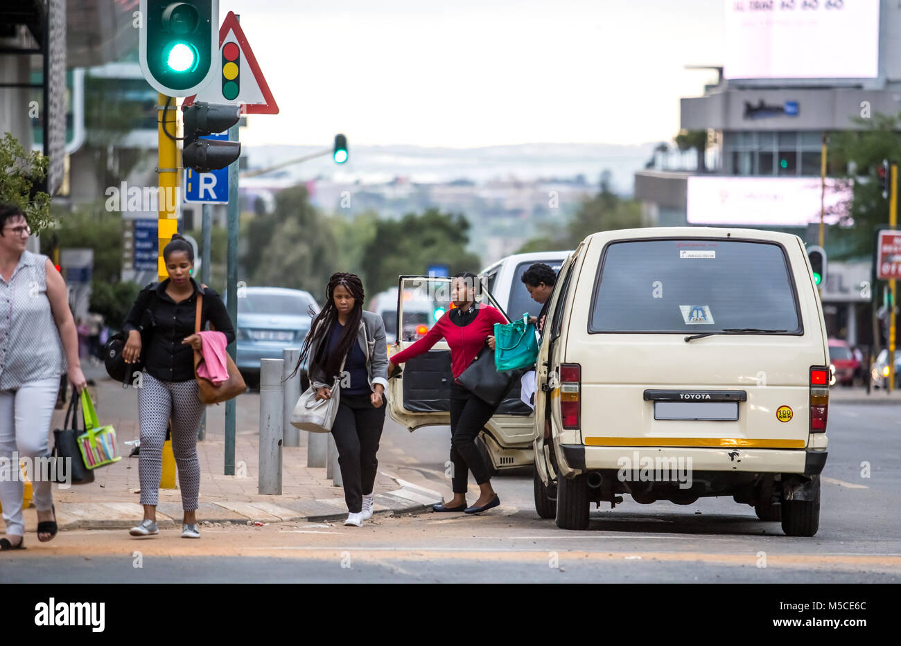 People getting out of taxi in city traffic. Johannesburg, South Africa -February 15, 2018 Stock Photo