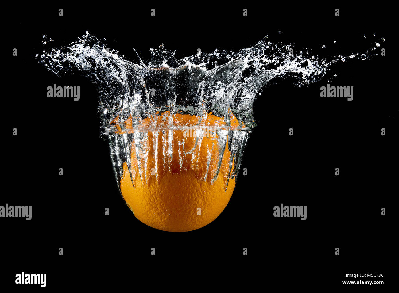 fresh orange in water splash on black background Stock Photo - Alamy