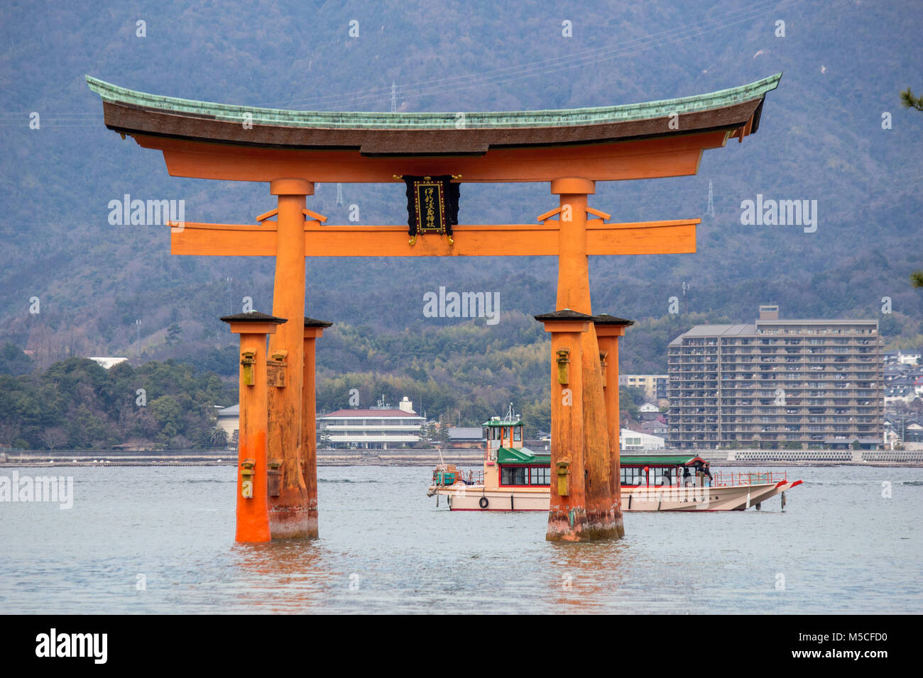 Itsukushima, also known as Miyajima, is a small island in Hiroshima Bay.Just offshore is the giant, orange Great Torii Gate. Stock Photo