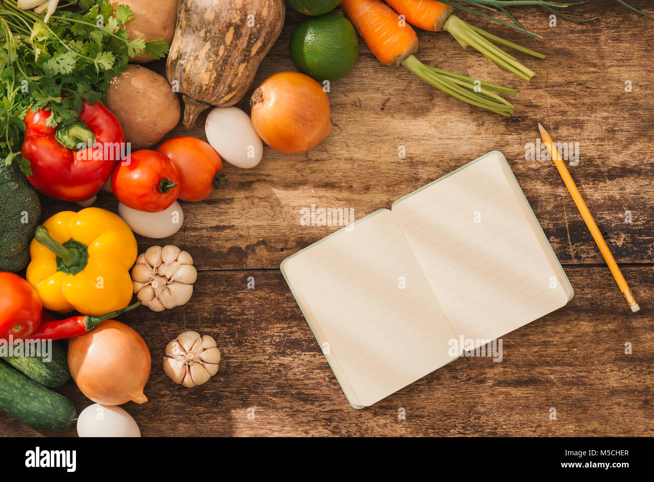Cooking classes concept. Fresh vegetables around open notebook on table ...