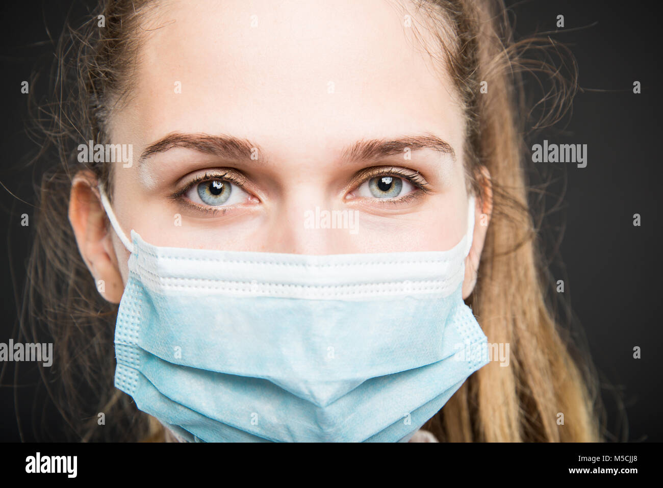 Close-up of doctor portrait posing with sterile mark on on black ...