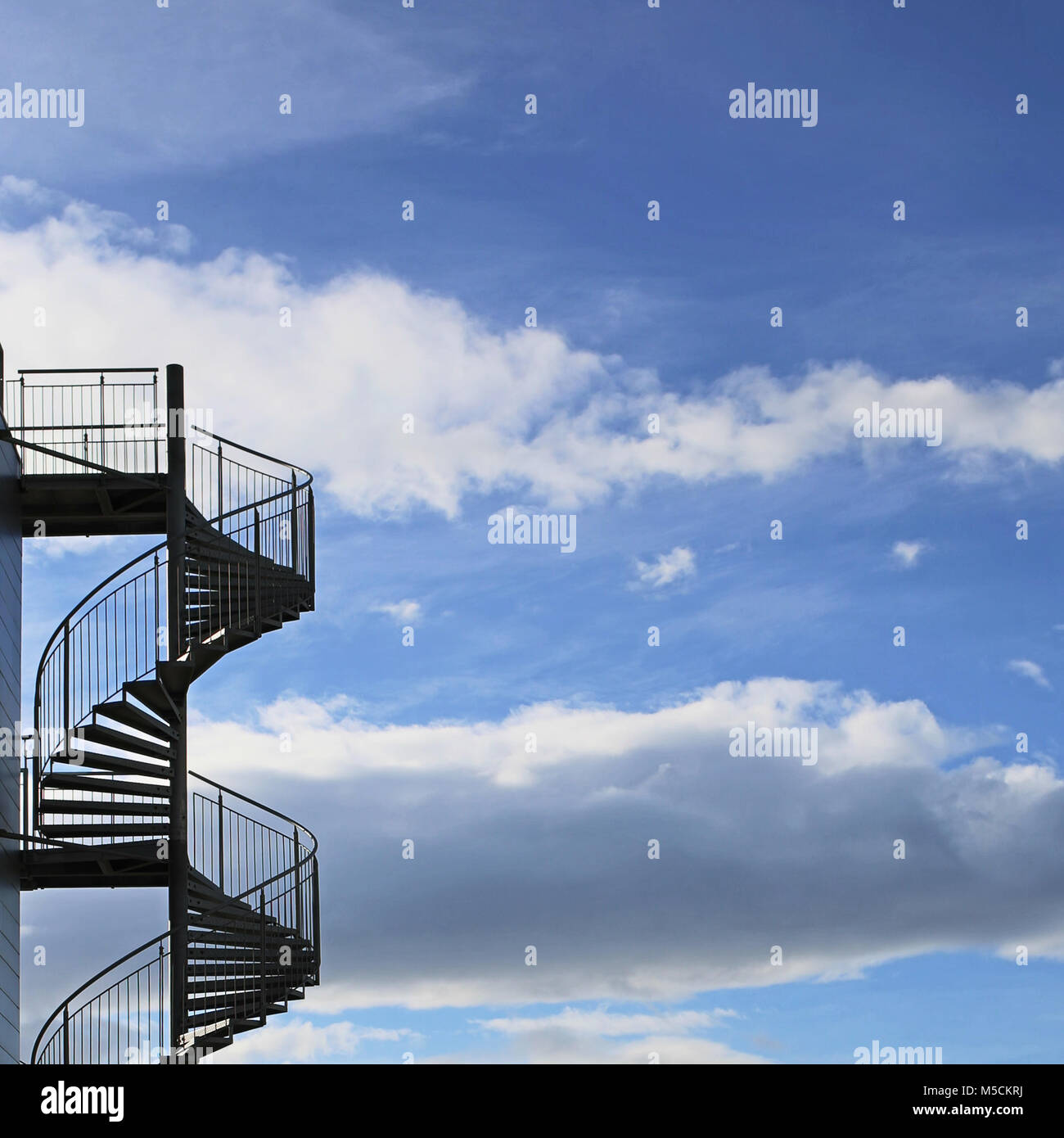 spiral staircase against clouds in blue sky Stock Photo