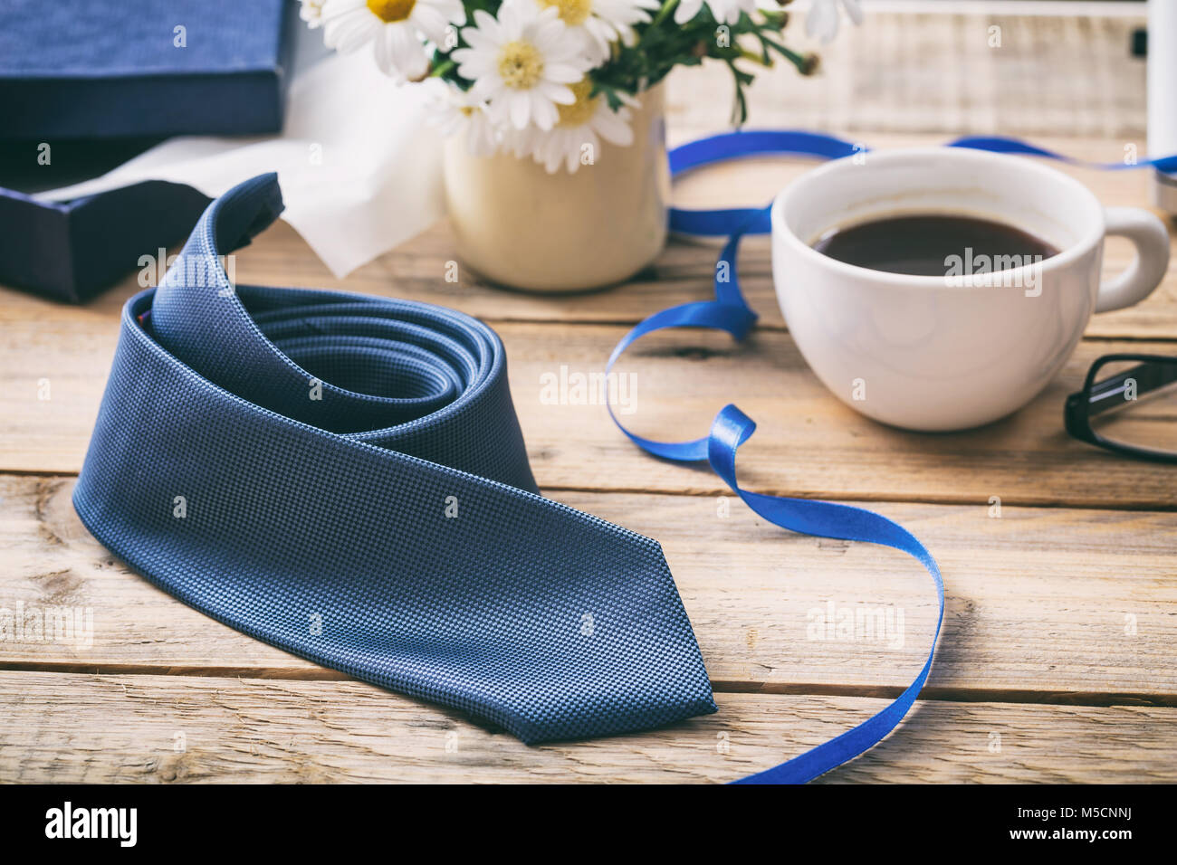 Father's day concept. Blue tie and an opened gift box, office desk