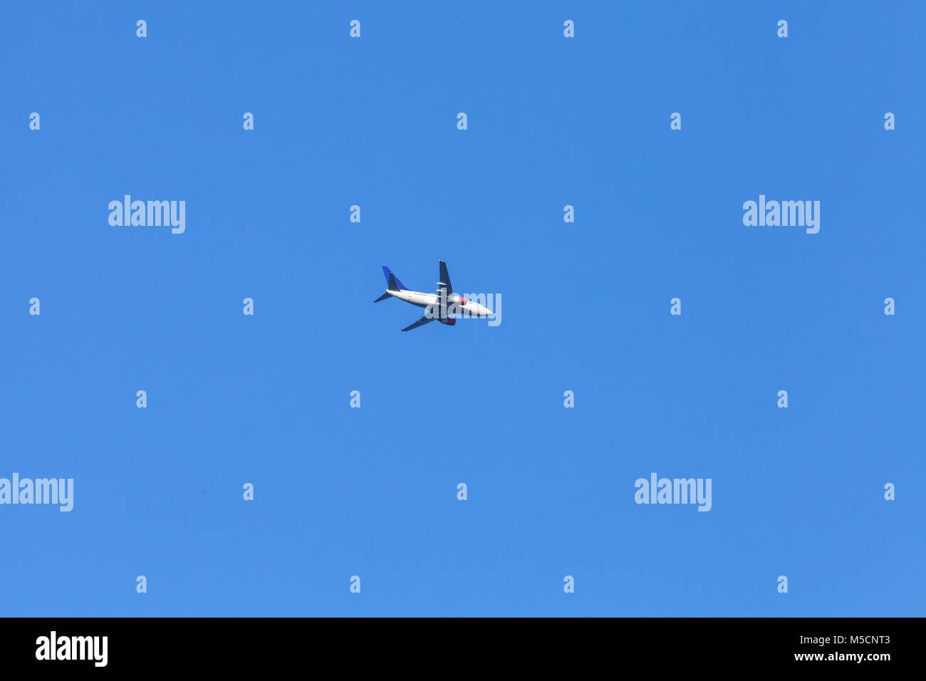 Passenger jet plane flies in blue sky Stock Photo Alamy