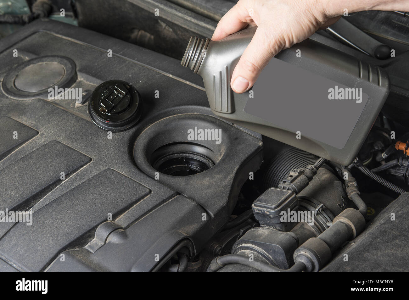 Add up oil to car engine from bottle Stock Photo Alamy