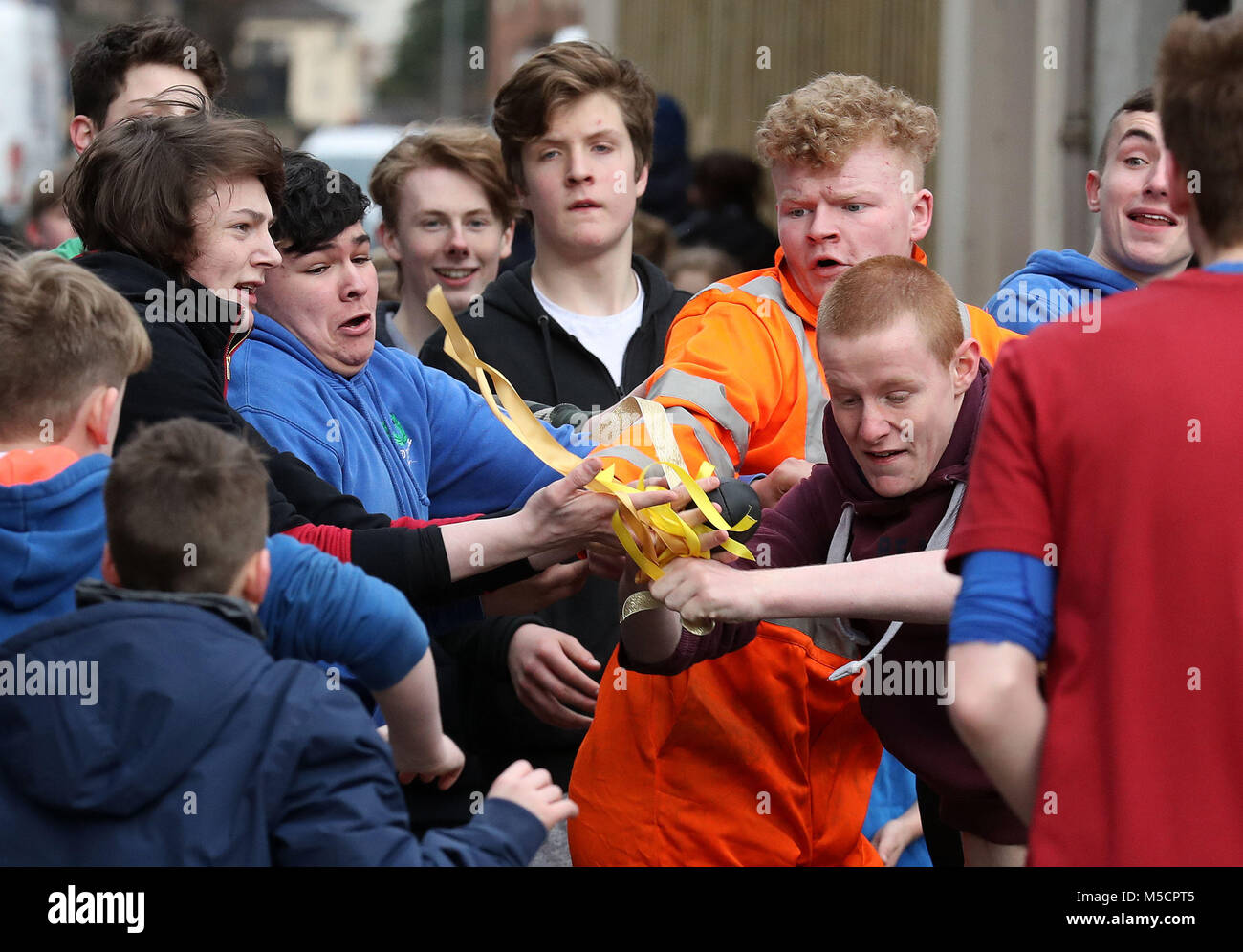 Boys tussle for the leather ball during the annual 'Fastern Eve Handba' event on Jedburgh's High Street in the Scottish Borders. The annual event, which started in the 1700's, involves two teams, the Uppies (residents from the higher part of Jedburgh) and the Doonies (residents from the lower part of Jedburgh) getting the ball to either the top or bottom of the town. The ball, which is made of leather, stuffed with straw and decorated with ribbons is thrown into the crowd to begin the game. Photo credit should read: Andrew Milligan/PA Wire. Stock Photo