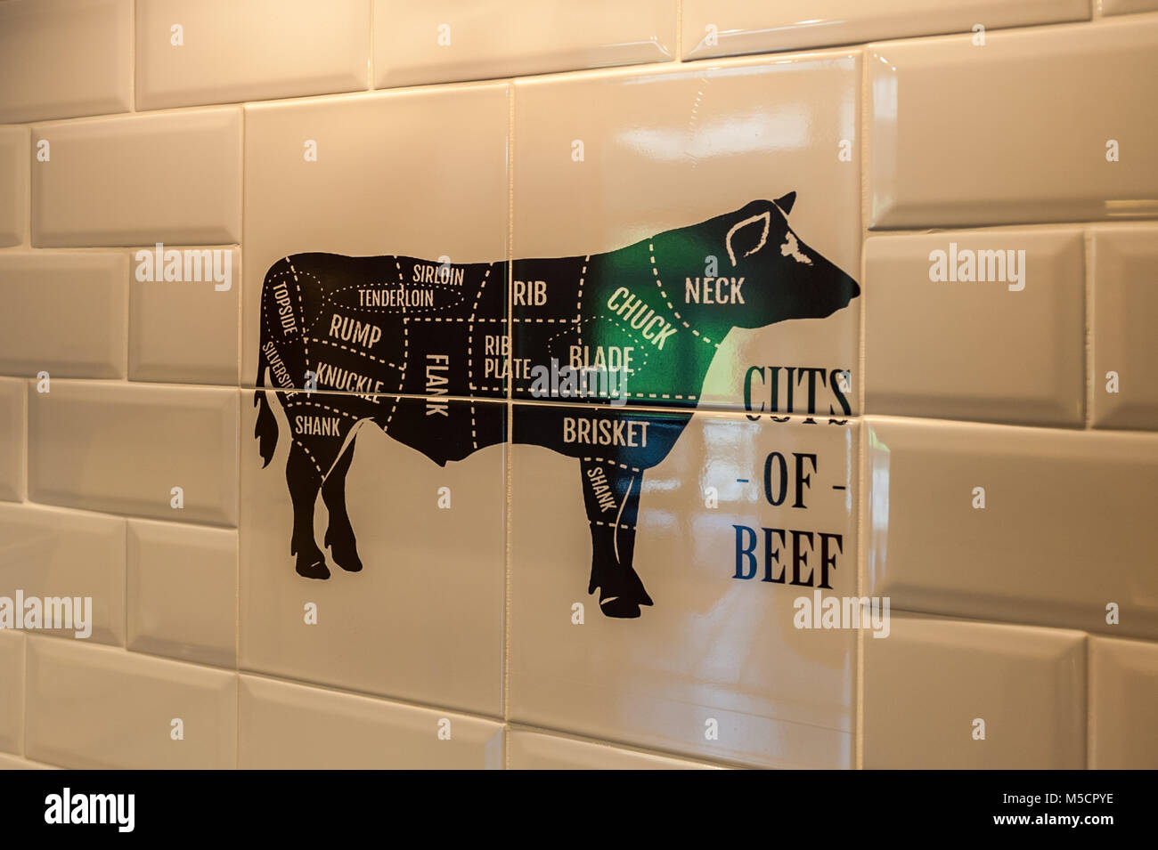 Illustration of cow made in decorative wall tiles showing cuts of meat - butchery concept with copy space. Stock Photo