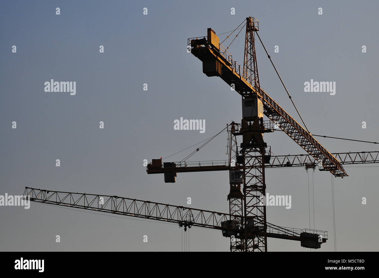 Construction cranes against evening hi-res stock photography and images ...
