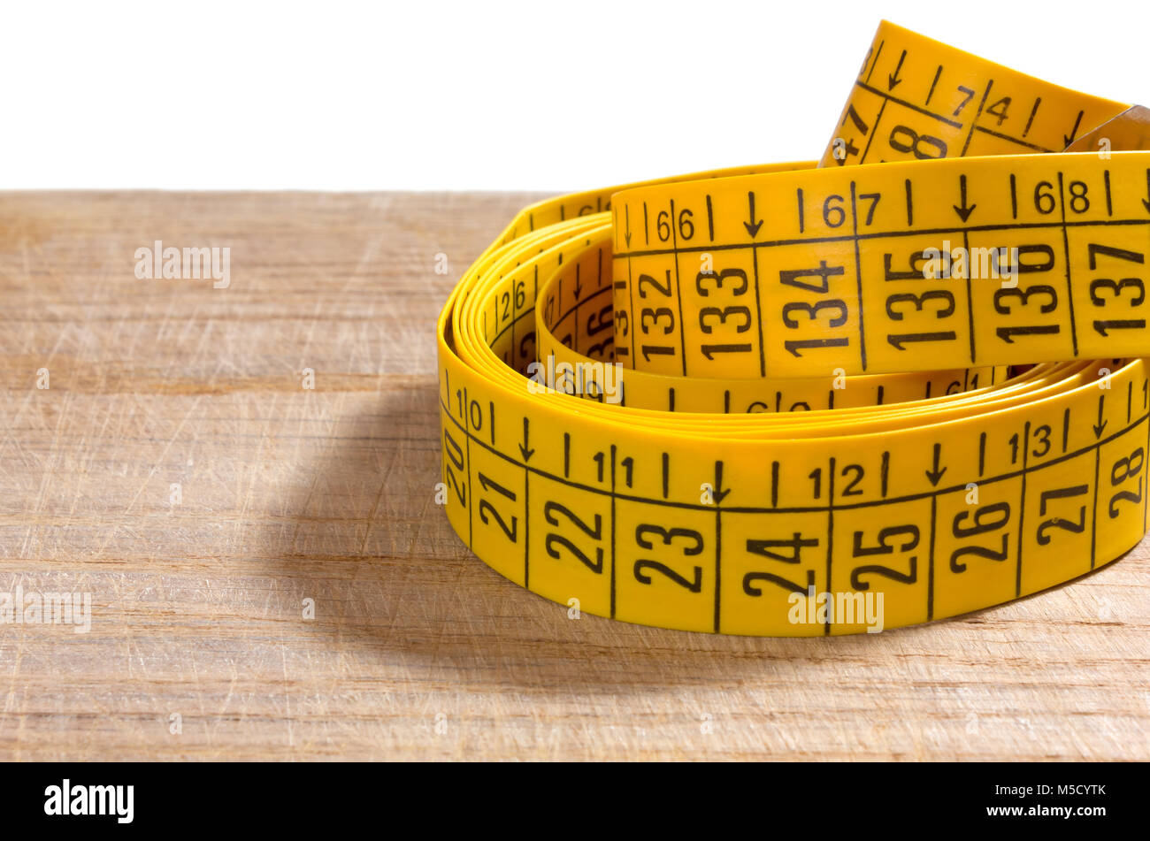 Yellow tailor tape measure on a wooden table, close up - a Royalty Free  Stock Photo from Photocase