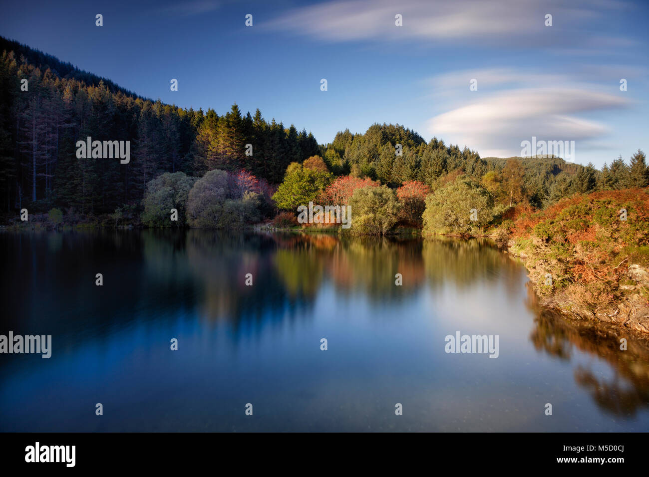 Long exposure image of autumn colours and lake in Snowdonia National Park in North Wales Stock Photo