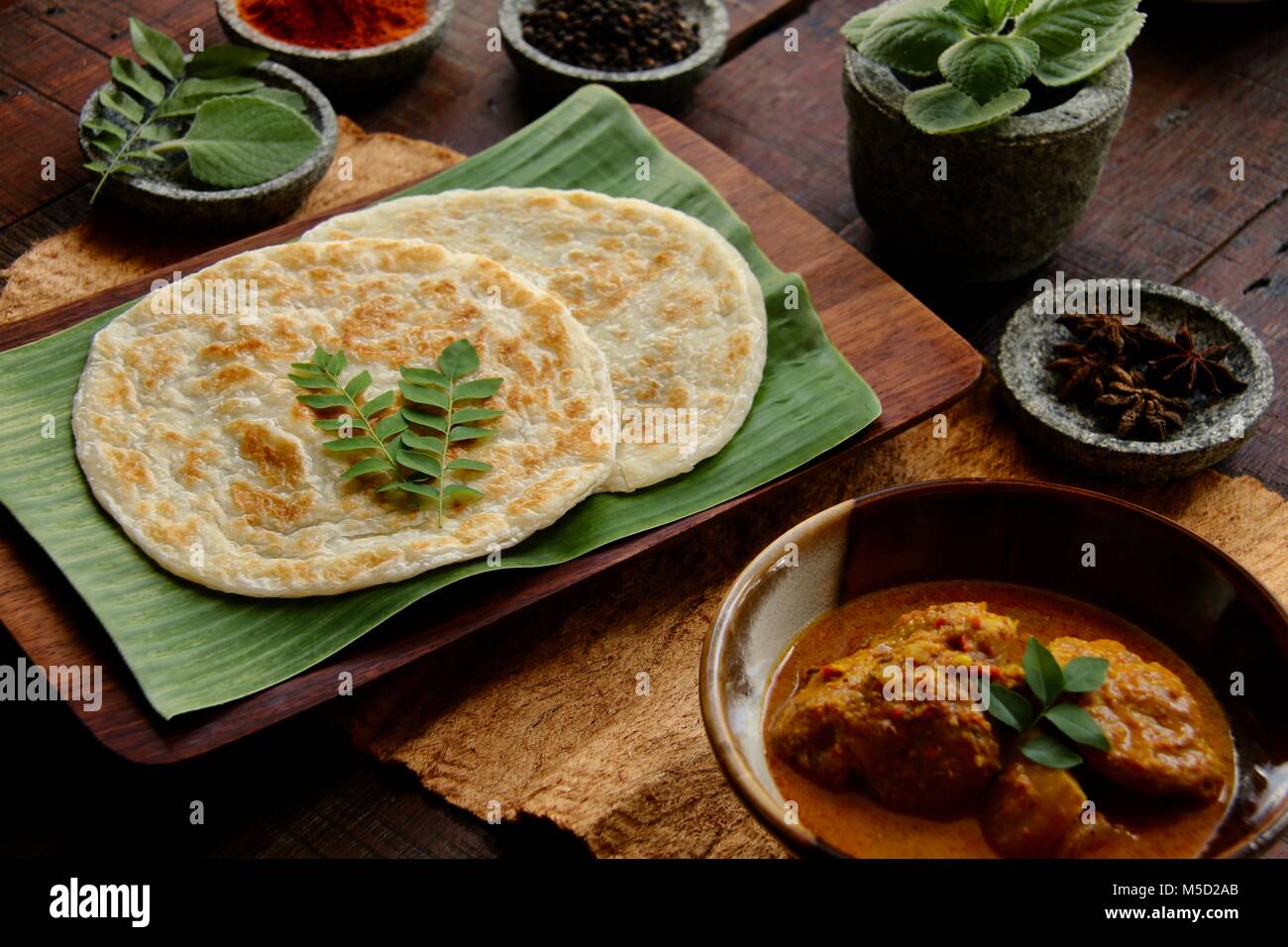 Roti Prata with Chicken Curry. Indian-influenced dish of flatbread with chicken and potato curry popular in Singapore and Malaysia. Stock Photo