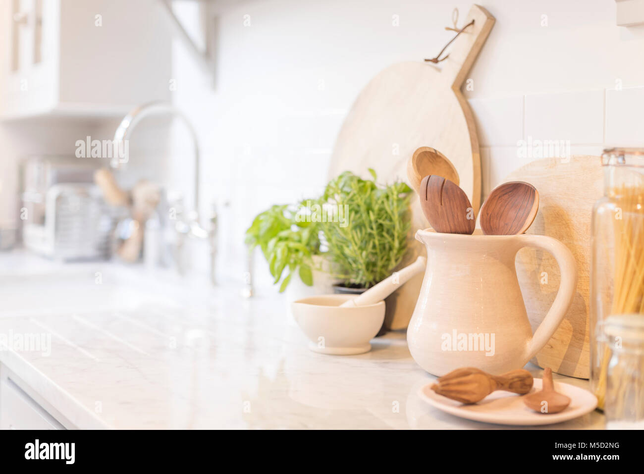 Still life wooden spoons in pitcher on kitchen counter Stock Photo