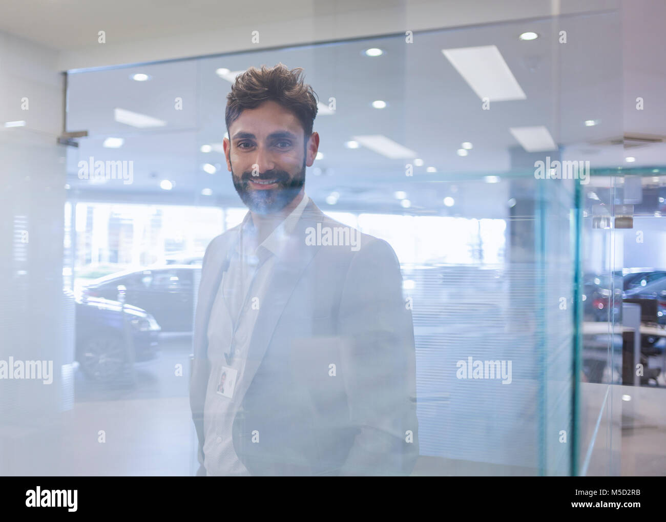 Portrait smiling, confident car salesman in car dealership showroom Stock Photo