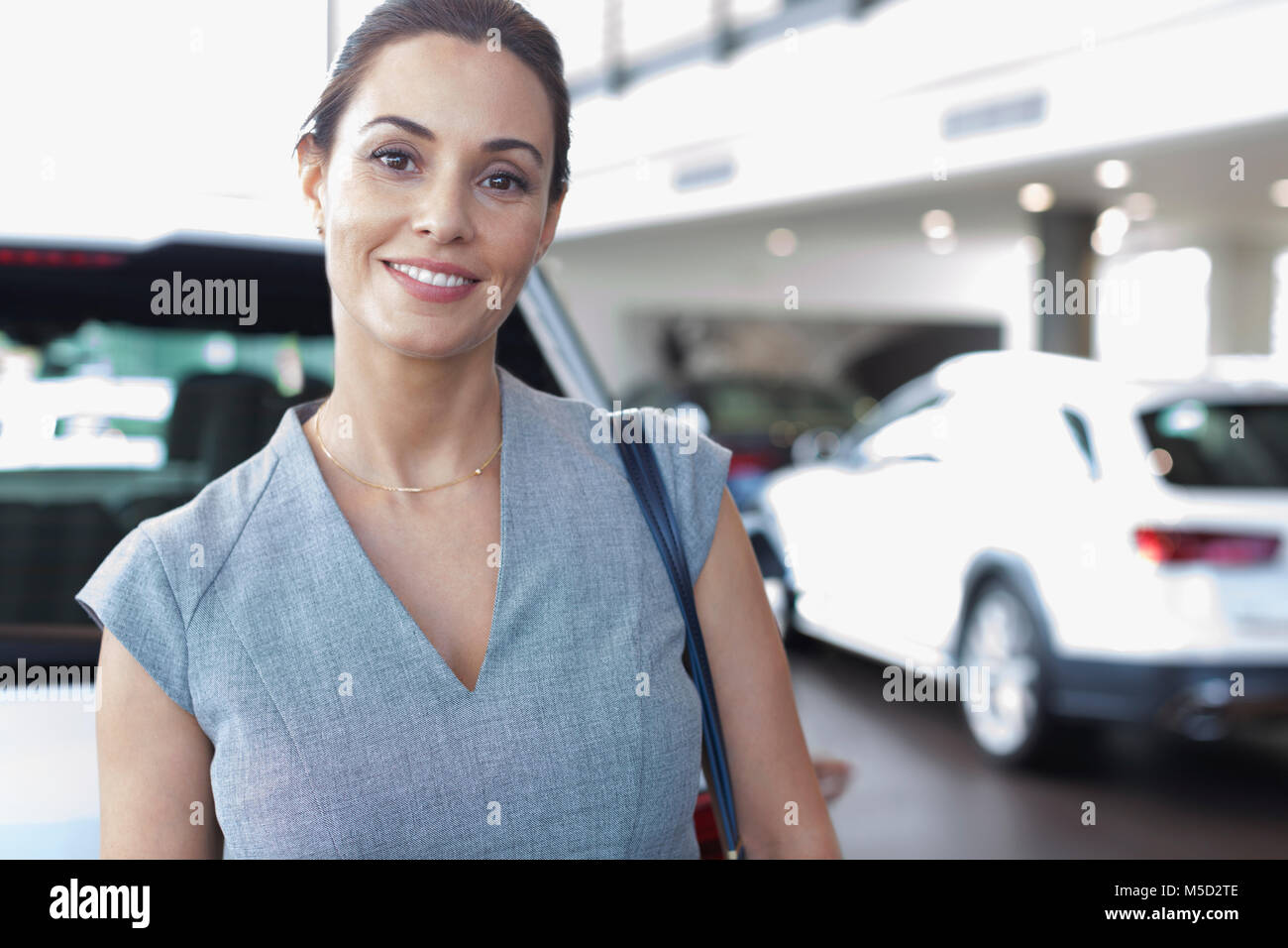 Portrait confident female customer in car dealership showroom Stock Photo