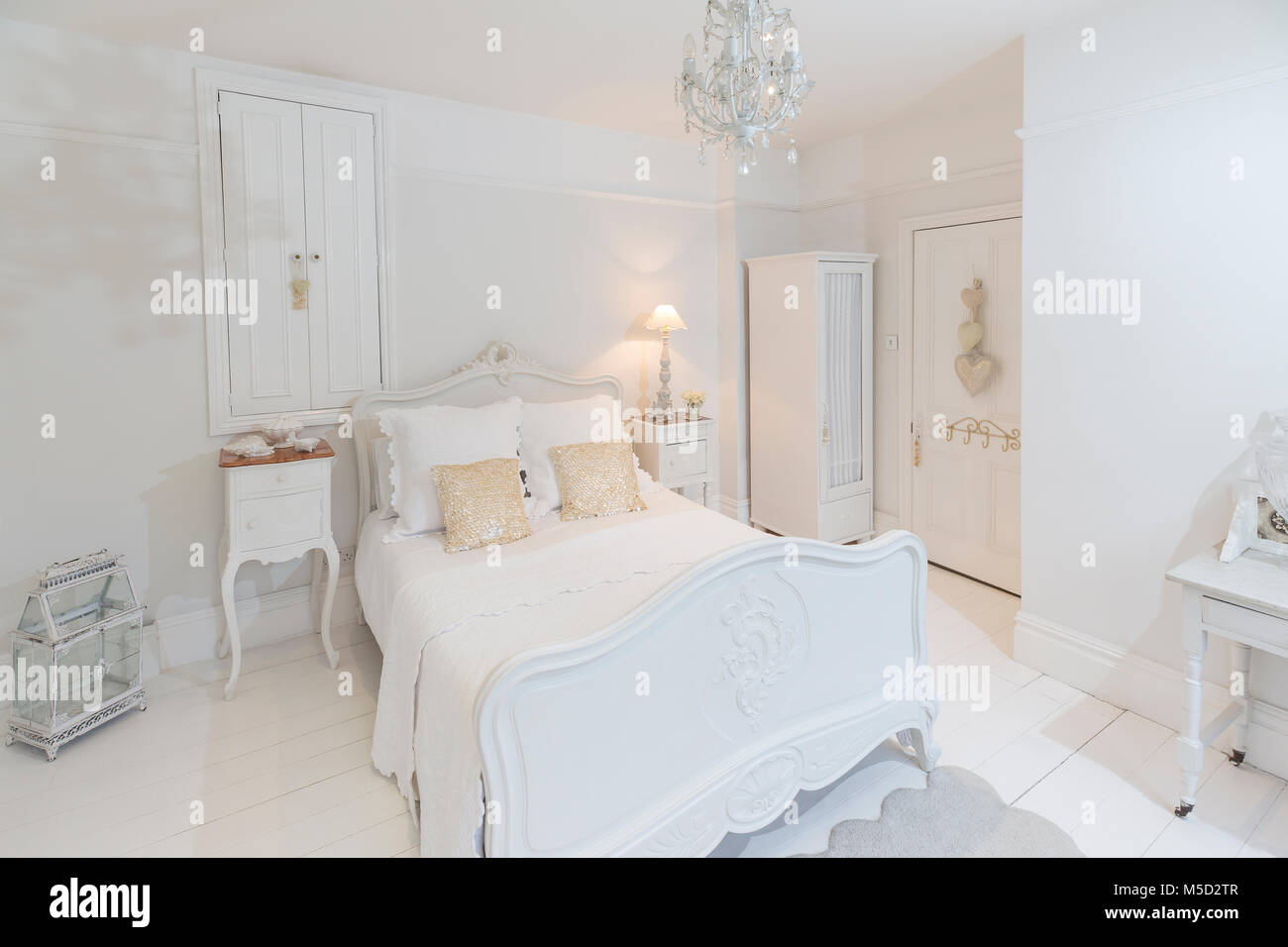 White, luxury home showcase bedroom with chandelier Stock Photo